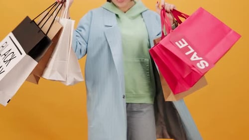 Stylish Woman with Shopping Bags on Yellow