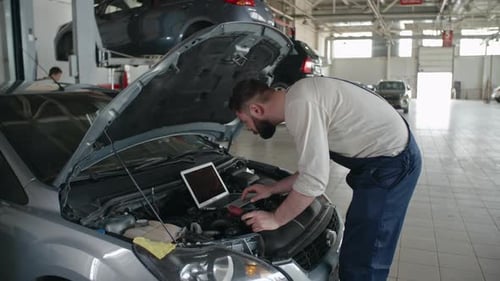 Mechanic Uses Tablet to Diagnose Car Engine