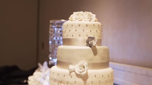 Close up of a beautiful wedding cake on a table in a banquet hall.
