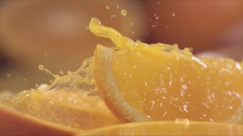 Slow Motion Shot of Orange Juice Splashing Through Orange Slices at 1400Fps