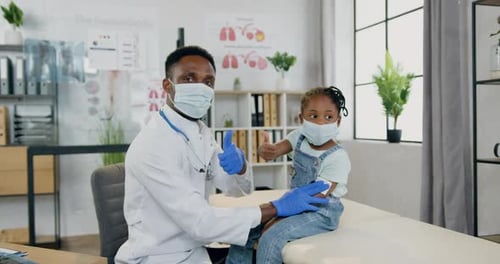 Friendly Doctor with Child Patient Giving Thumbs Up
