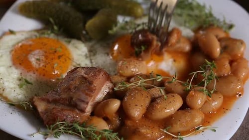Hearty Meal with Fried Eggs, Beans and Pickles