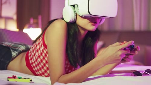 Woman Using VR Headset Lying on Bed Playing