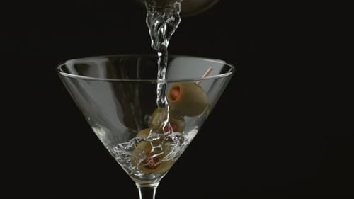 Clear Liquid Pouring Into Martini Glass with Olives