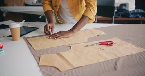 Fashion Designer Pinning Pattern to Fabric in Studio