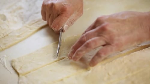 Hands Cutting Dough With Knife