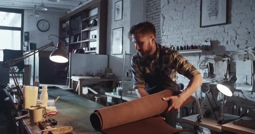 Man Unrolls Leather Roll at Bright Workshop