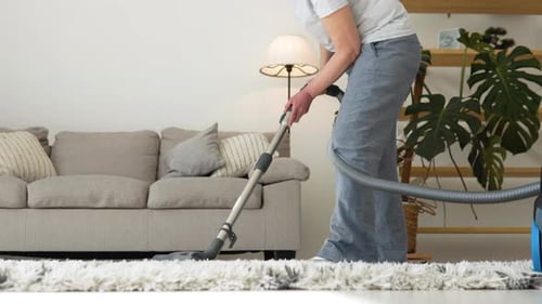Adult Vacuuming Rug in Living Room