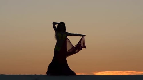 Woman Dancing in Desert at Sunset