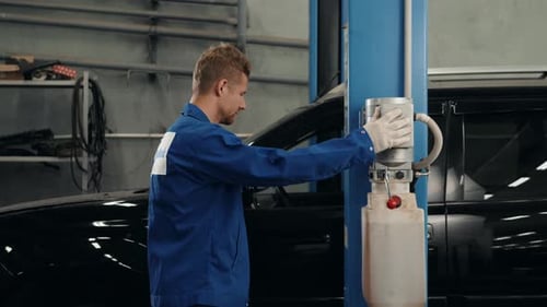 Car Mechanic Lift Automobile with Spanner Tighten Car Suspension Detail of Lifted Automobile at
