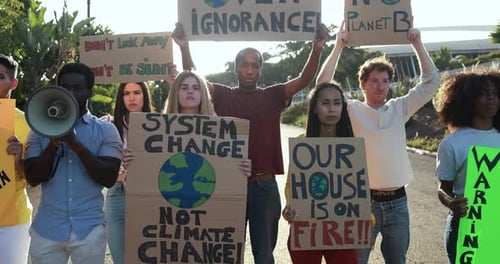 Un groupe de jeunes manifestants issus de cultures et de races différentes manifestent sur la route pour protester contre le changement climatique