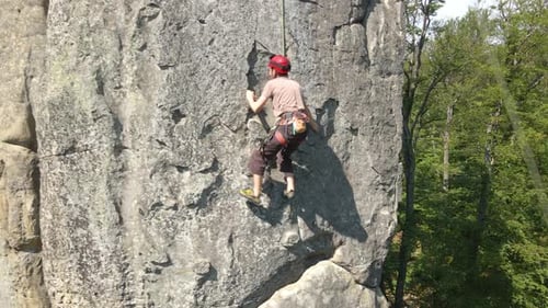 Strong Male Climber Climbing Steep Wall of Rocky Mountain