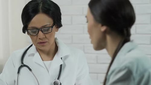 Mature Doctor Talking to a Younger Patient