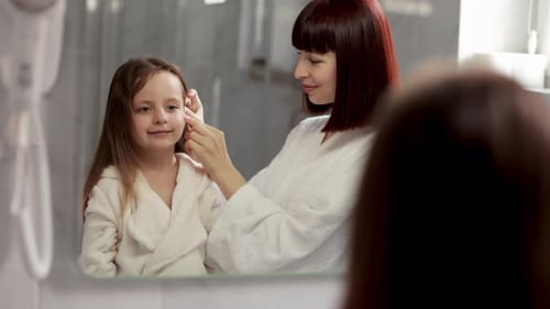 Mother Tending to Daughter's Hair in Bathroom