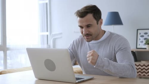 Man Working on Laptop, Celebrating Success