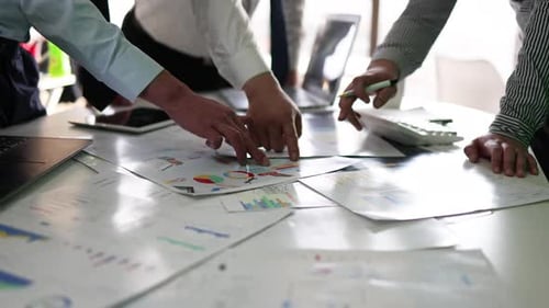 Equipes da empresa discutem gráficos de dados de trabalho e negócios em pequenos grupos