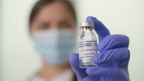 Closeup a Vial with the COVID19 Coronavirus Vaccine in the Hand of a Doctor