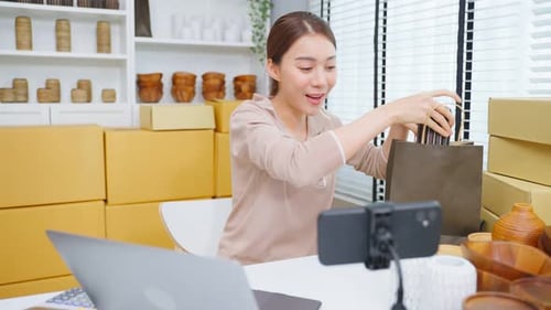 Asian beautiful woman sell vase product online live streaming at home.