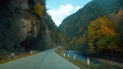camera shoots from first person, car is driving along a narrow mountain road.