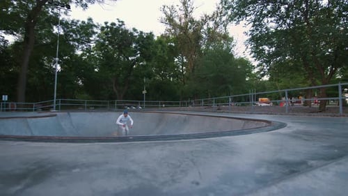 Patineur à roulettes en ligne agressif faisant des tours dans un skatepark en béton à l'extérieur au Ralenti