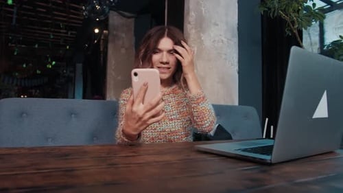 Happy Girl Blogger Talking on the Phone While Sitting in a Cafe