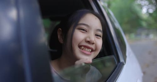 Teen Girl Smiling Out of a Car Window