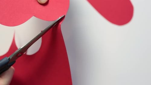 Cutting Red Paper Hearts for Valentine's Day Card