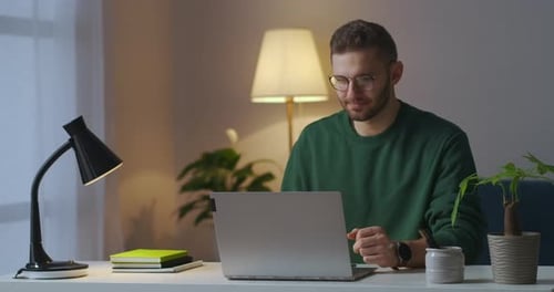 Man Talks on Laptop in Home Office