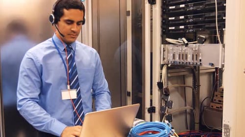 Technician Working with Laptop in Server Room