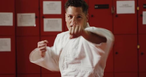Man Practicing Punches in Front of Lockers