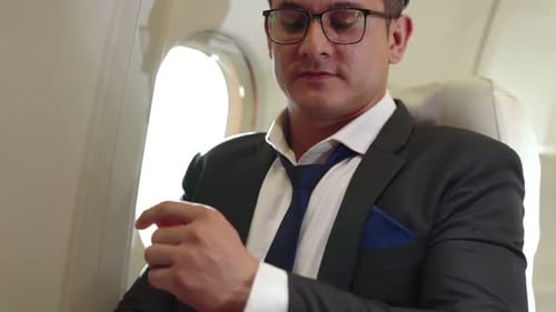 Man Working on Laptop on Airplane