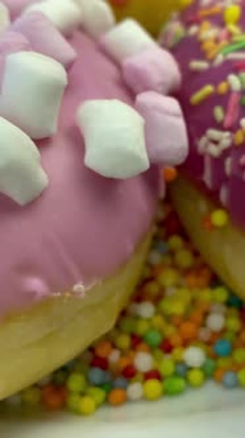 Assorted Delicious Donuts with Icing and Sprinkling Rotates on White Plate