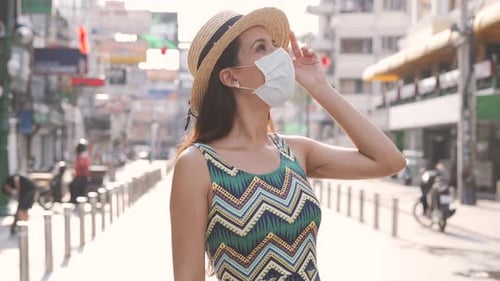 Woman in Mask Walks Down Sunny City Street
