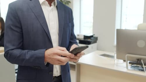 Businessman Using Smartphone in a Modern Office