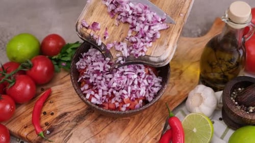 Diced Onion Being Added To Bowl of Tomatoes