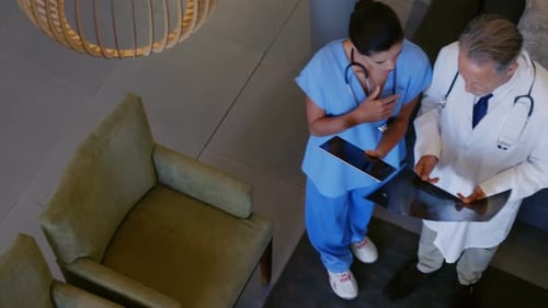 Des médecins caucasiens de sexe masculin et métisse travaillant ensemble dans un centre médical, regardant un scanner