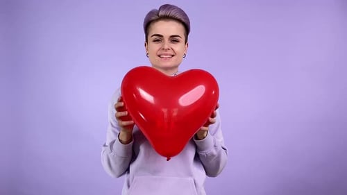 Young Adult Holding Red Heart Shaped Balloon