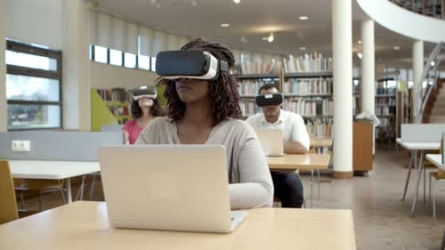 Front View of Young Woman with VR Glasses Sitting at Library