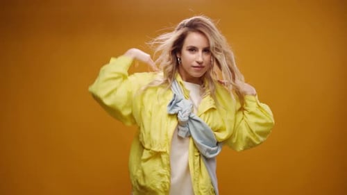 Woman Professional Dancer Dancing in Studio Against Yellow Background
