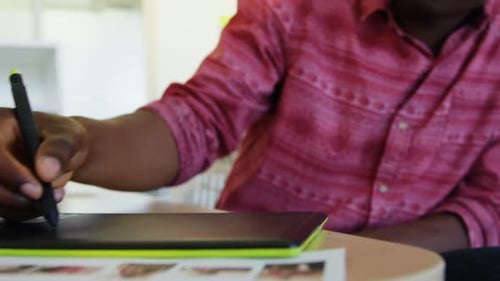 Young Adult Drawing on Tablet in Office