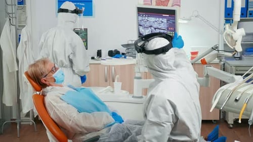 Dentists Attending to Senior Woman Patient in Office