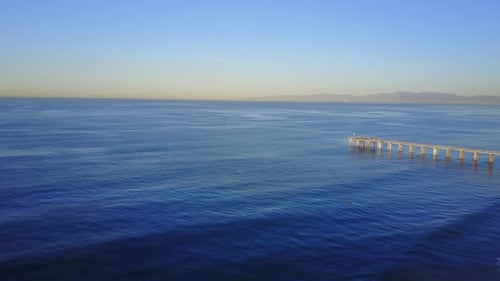 Aerial drone uav view of a pier over the beach and ocean.