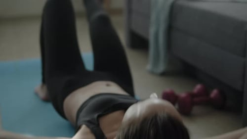 Woman Does Crunches on Yoga Mat at Home