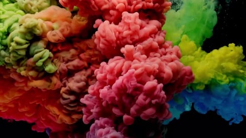 Bunte Regenbogenfarbe lässt sich von oben in Wasser mischen. Unter Wasser wirbelnde Tinte.