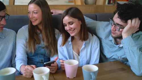 Young Friends Sit in a Cafe Drink Coffee and Have Fun Communicating