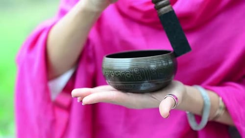 Woman Plays a Singing Bowl Outdoors
