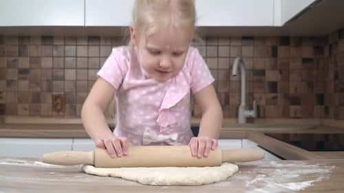 Little Girl Rolling Dough in Kitchen