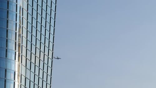 Landschaft mit Seitenfassade aus modernem Gebäude und Flugzeugfliegen. Statische