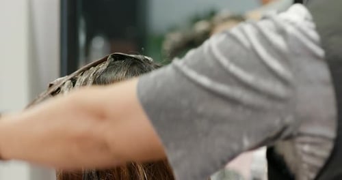 Hair Stylist Applies Dye in Salon Setting