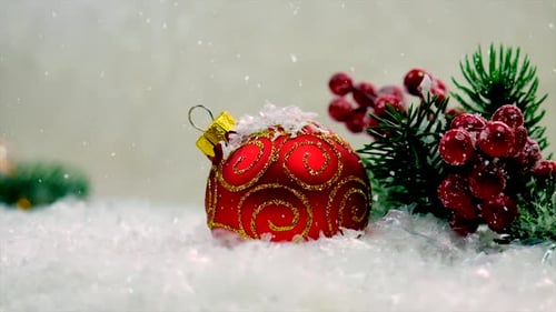 Red Christmas Ornament in Snow with Falling Snow
